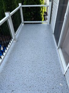 A smooth light gray floor with a texture of small pebbles covers the terrace