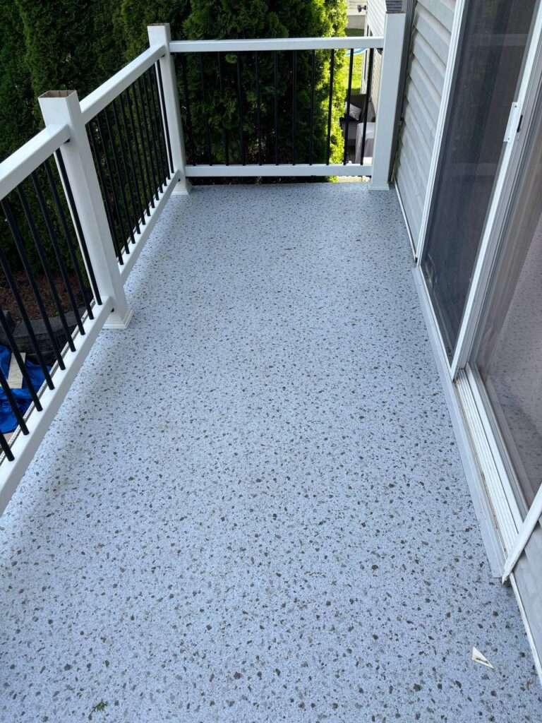 A smooth light gray floor with a texture of small pebbles covers the terrace