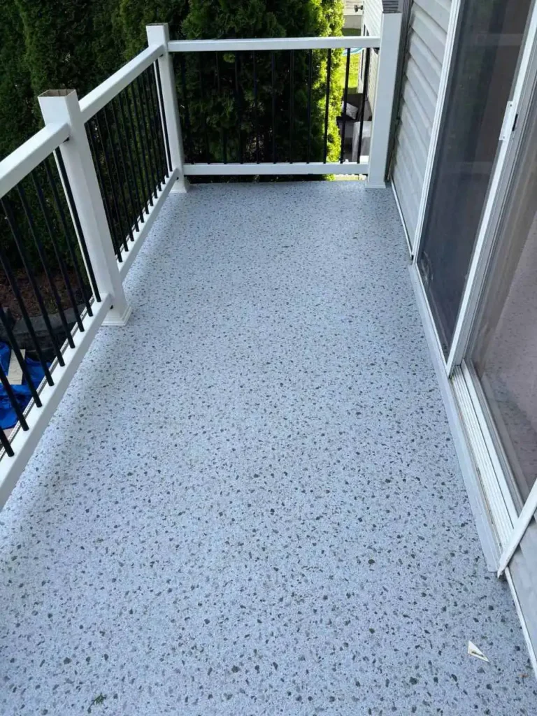 A smooth light gray floor with a texture of small pebbles covers the terrace